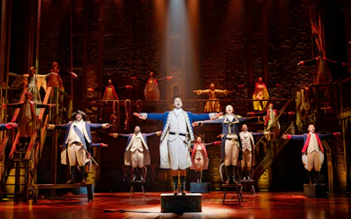 Hamilton cast performing on stage, West End production.