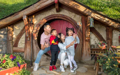 Family taking a selfie at Hobbiton Movie Set entrance, Auckland tour.