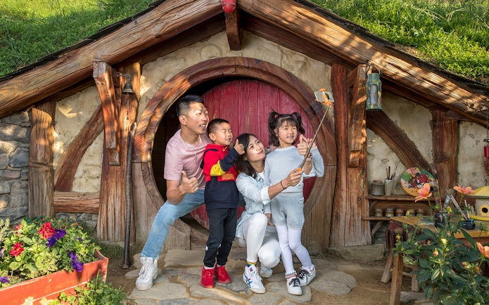 Family taking a selfie at Hobbiton Movie Set entrance, Auckland tour.