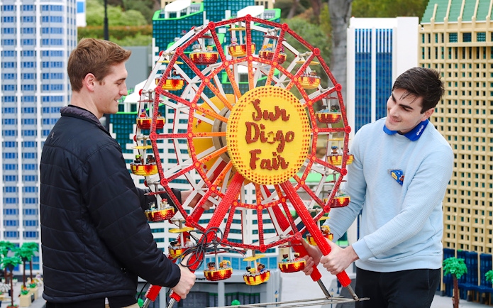 Two people adjusting a LEGO Ferris wheel at MINILAND USA, LEGOLAND® California.