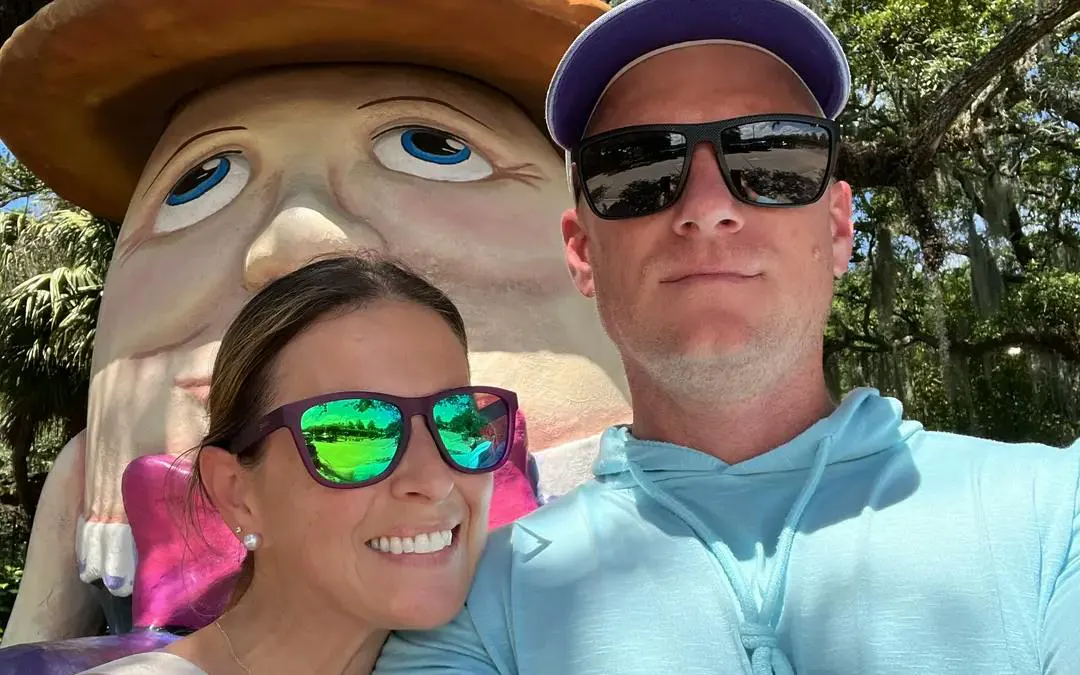 Couple posing with Humpty Dumpty statue during New Orleans city exploration game.