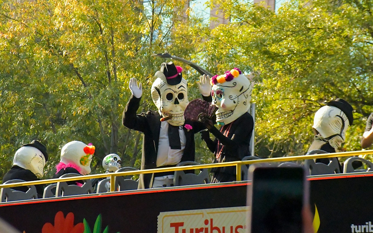 Participants in skeleton costumes on a bus during Day of the Dead parade, Mexico.