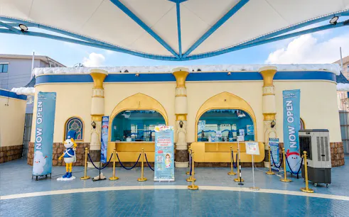 Ticket booth with cartoon character statue at an attraction in Phuket old town.