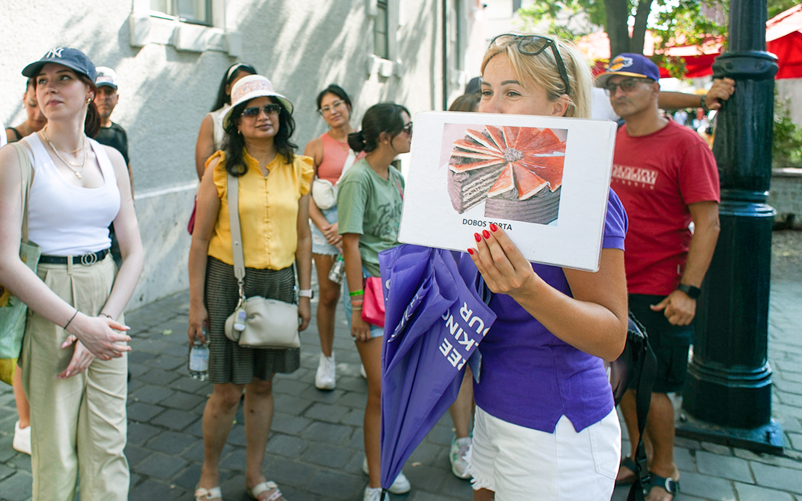 Tour guide showing Dobos Torta image to group during St. Stephen's Basilica tour.