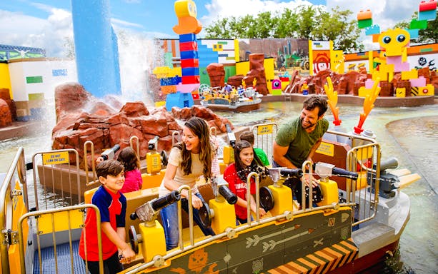 Families enjoying water ride at Battle of Bricksburg, Legoland Florida.