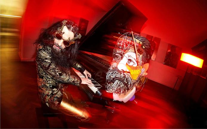 Man playing piano with surreal art installation at IAM Illusion Art Museum Prague.