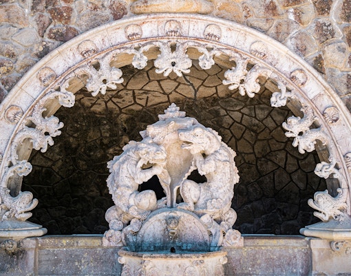 Tour guide with group in Quinta da Regaleira gardens, Sintra, Portugal.