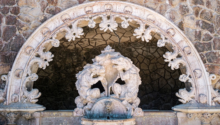 Tour guide with group in Quinta da Regaleira gardens, Sintra, Portugal.