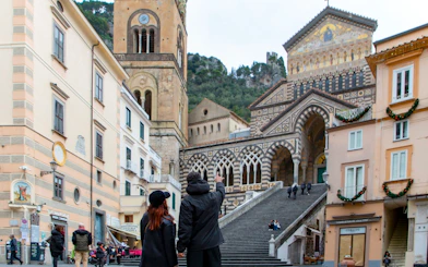 Amalfi Cathedral facade with people on steps in Amalfi, Italy.