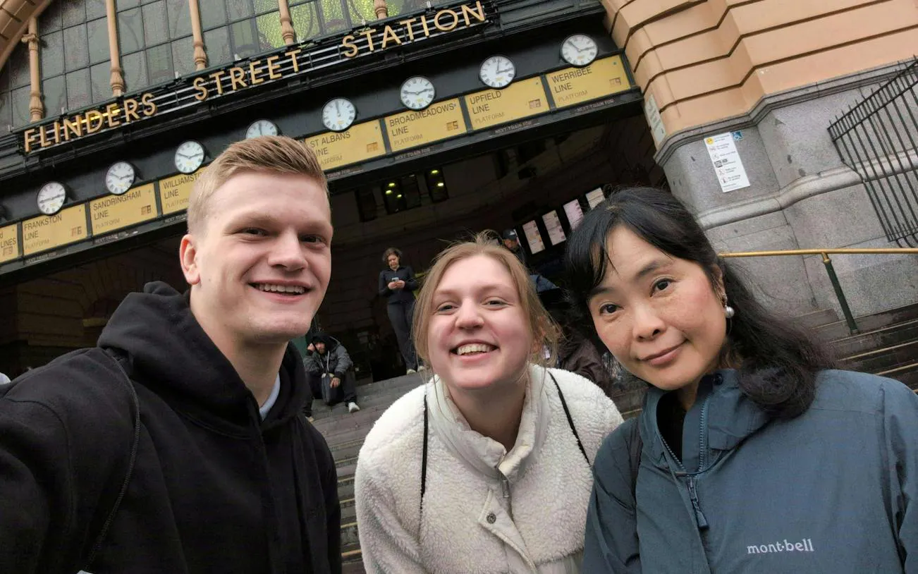 Flinders Street Station entrance with three people smiling, Melbourne Forgotten Red Diamond tour.