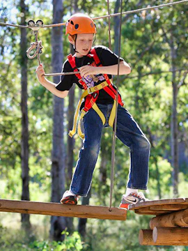 Child navigating ropes course at TreeTops Adventure Park.