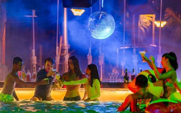 Guests enjoying drinks at Andamanda Phuket EDM concert poolside bar.