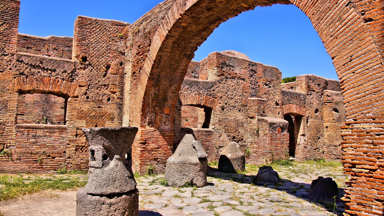 Ancient millstones and brick arches at the Bakery of Ostia Antica, Italy.
