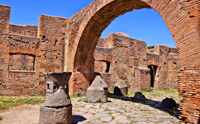 Ancient millstones and brick arches at the Bakery of Ostia Antica, Italy.