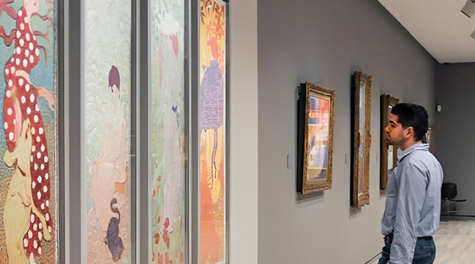 Visitor admiring colorful art at Fundación MAPFRE Madrid gallery.
