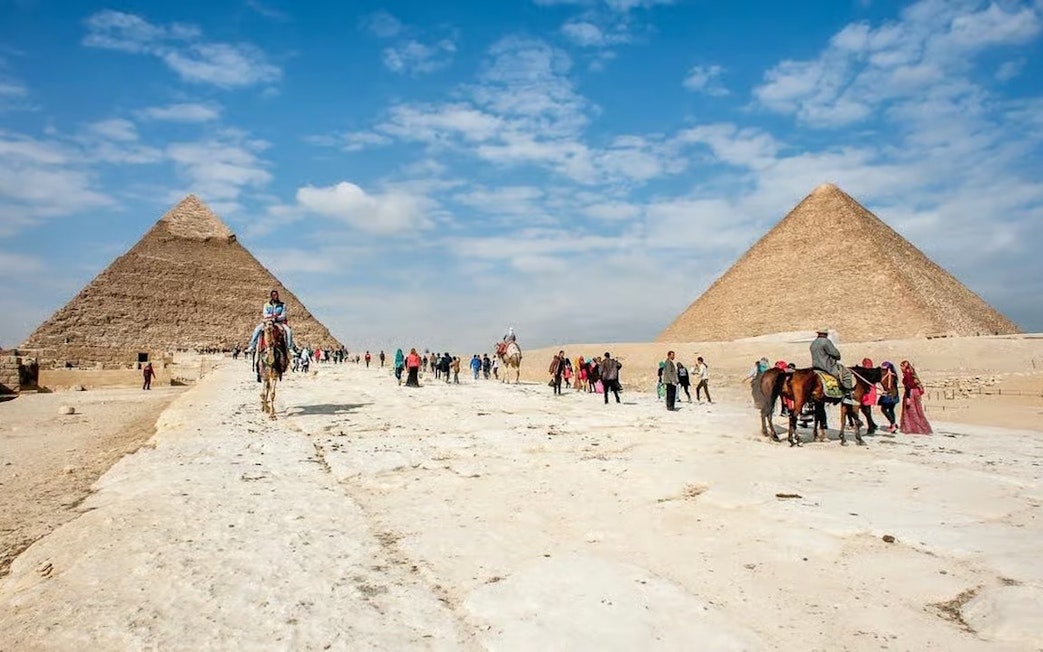 Visitors exploring the Pyramids of Giza on a day trip from Hurghada, Cairo.