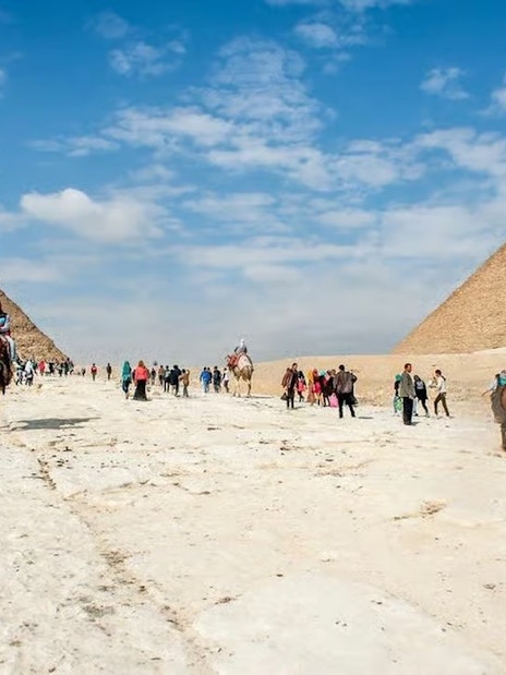 Visitors exploring the Pyramids of Giza on a day trip from Hurghada, Cairo.