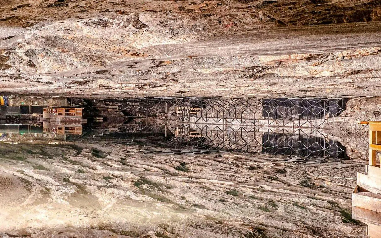 Inside view of Berchtesgaden Salt Mine with reflective underground lake and rock formations.