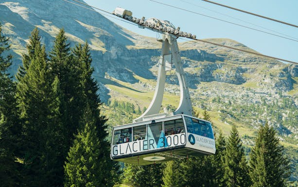Cable car ascending to Glacier 3000 in Switzerland with mountain backdrop.