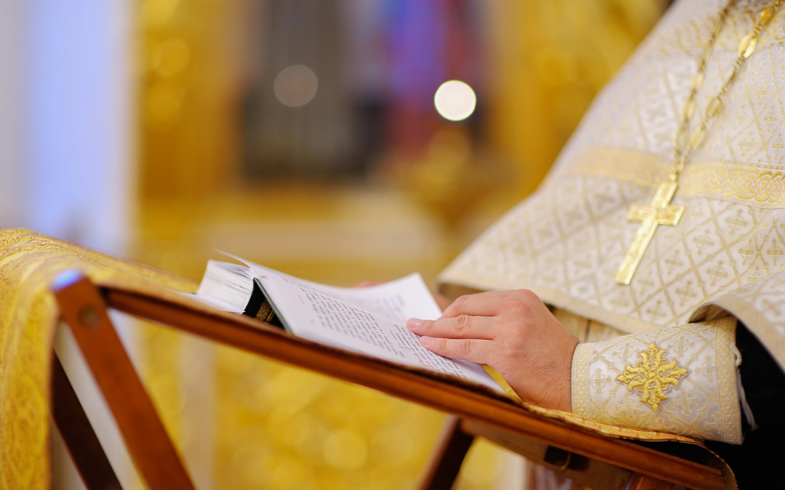 Priest reading from a church bible during mass in a historic cathedral, Rome, Italy.