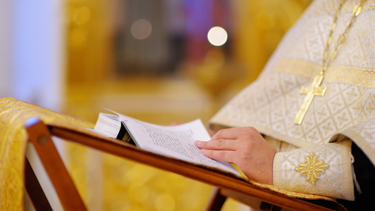 Priest reading from a bible during church mass.