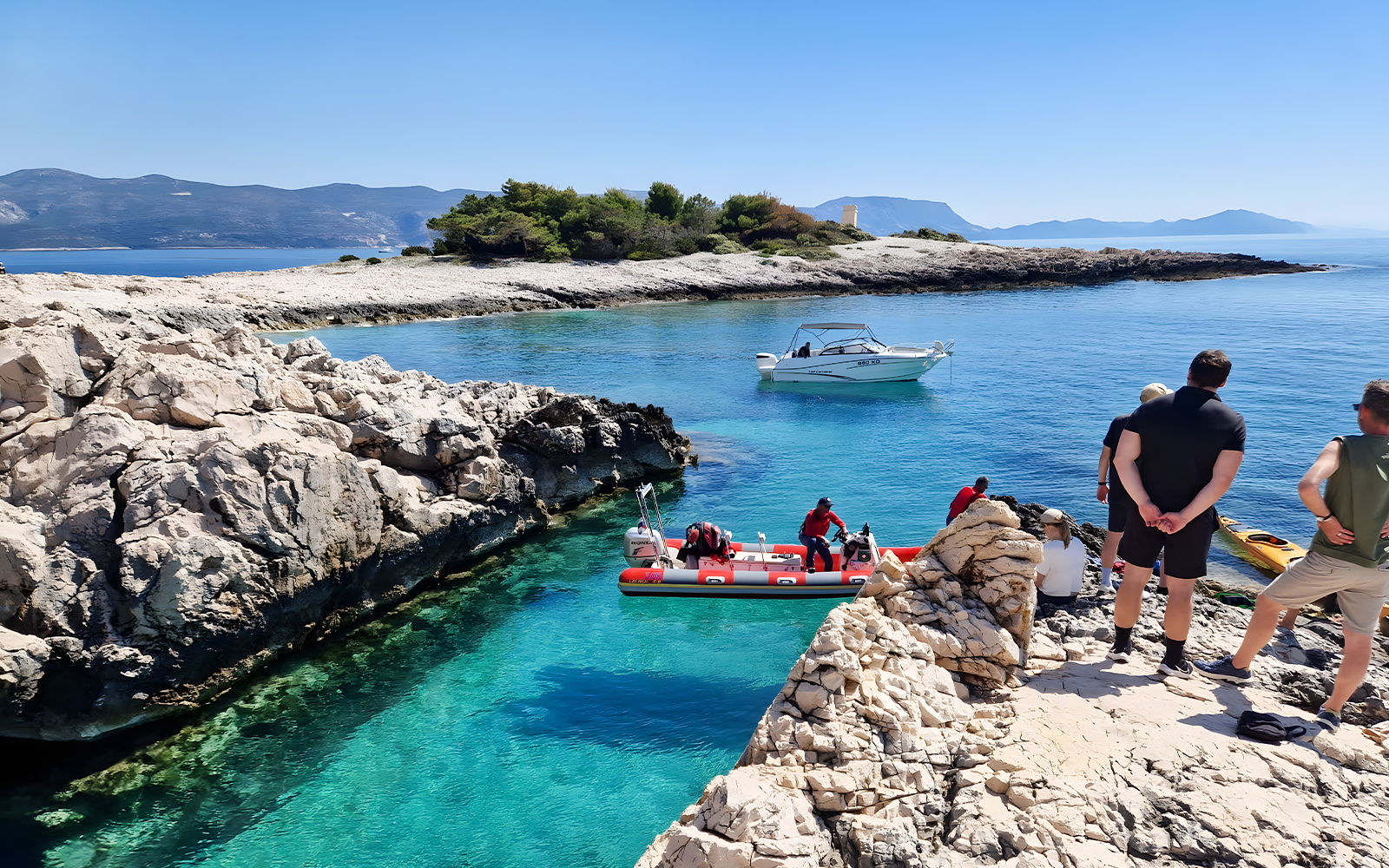 Snorkeling and swimming at a hidden beach in Korčula, Dubrovnik with boats and rocky shoreline.