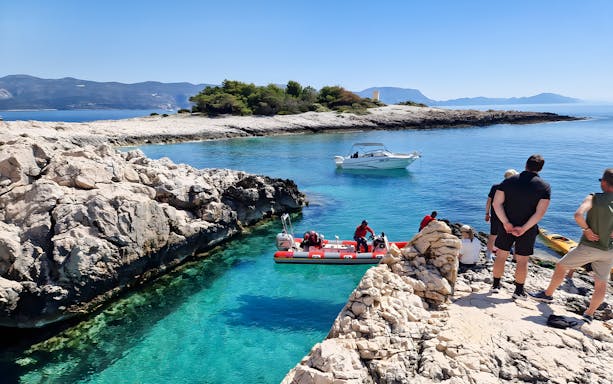 Snorkeling and swimming at a hidden beach in Korčula, Dubrovnik with boats and rocky shoreline.