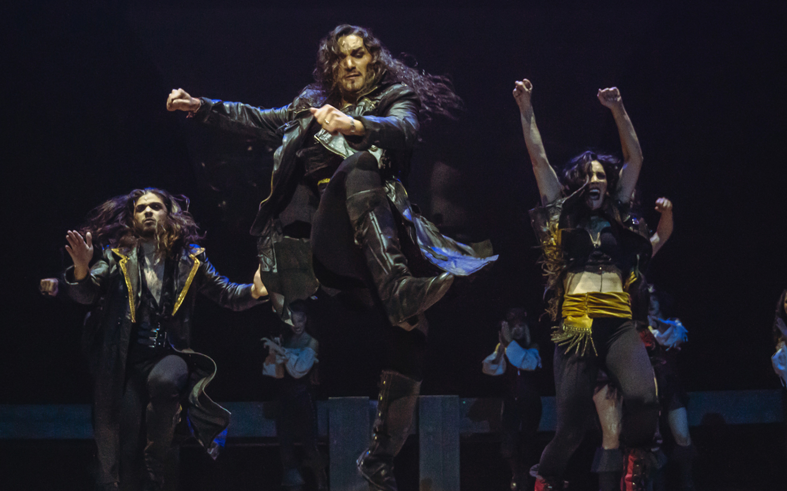 Performers dancing energetically in "MALINCHE, un musical de Nacho Cano" stage show.