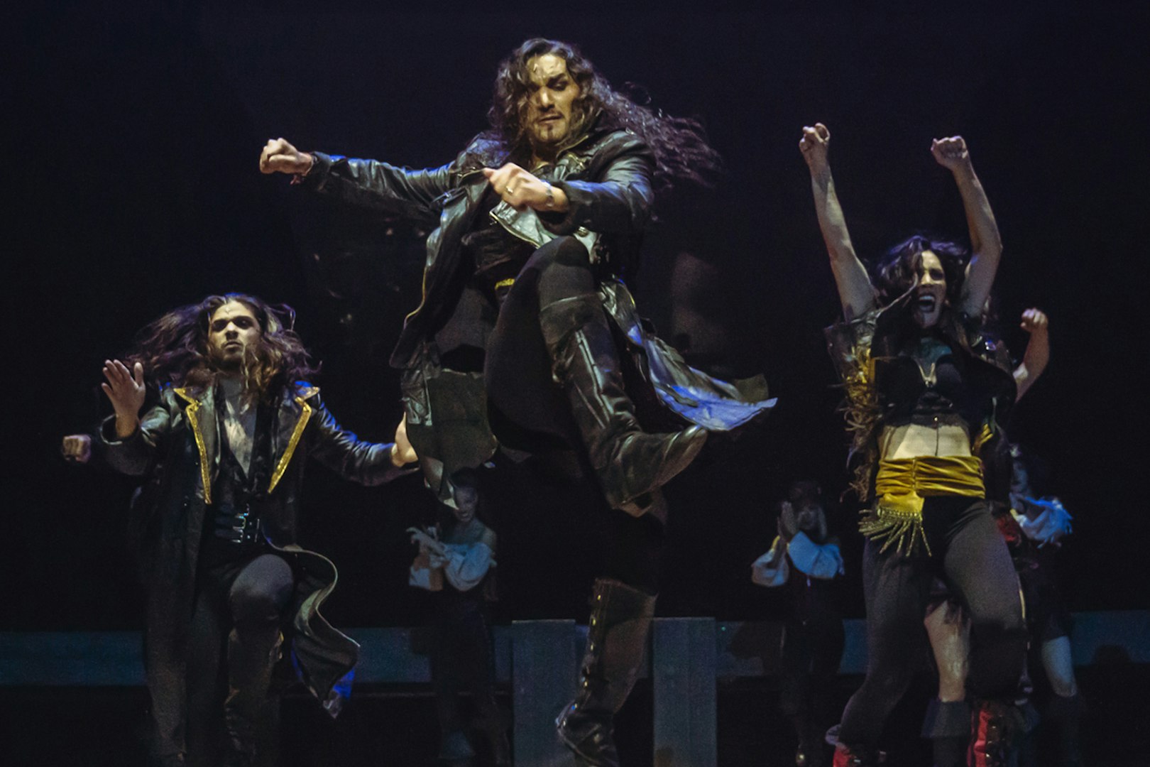 Performers dancing energetically in "MALINCHE, un musical de Nacho Cano" stage show.