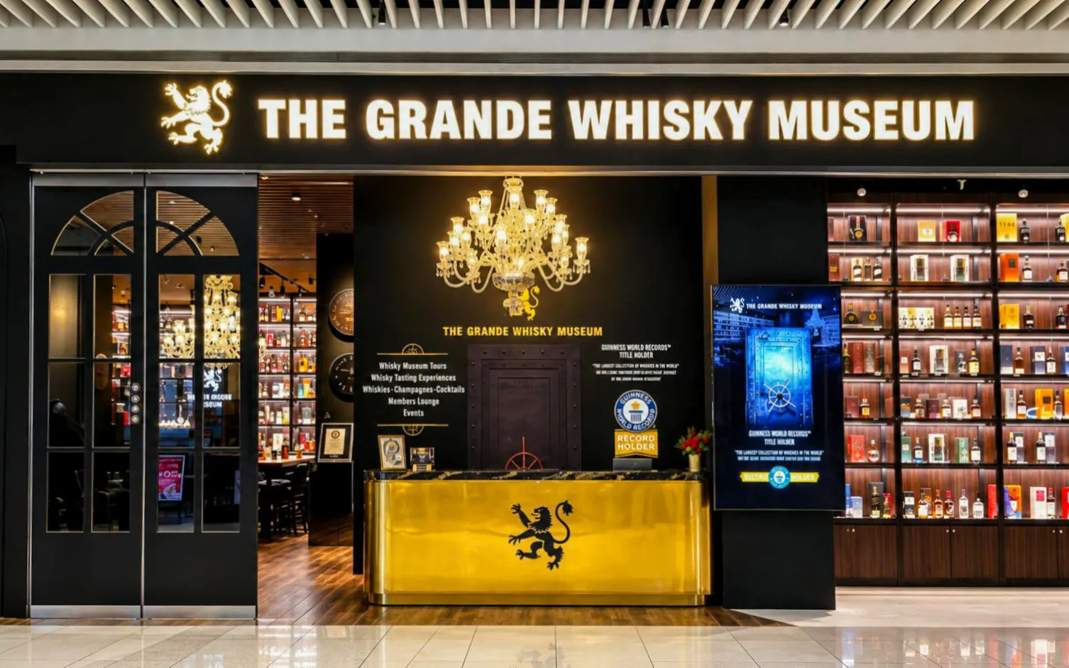 Grande Whisky Museum entrance in Singapore showcasing whisky bottles and chandelier.