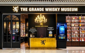Grande Whisky Museum entrance in Singapore showcasing whisky bottles and chandelier.
