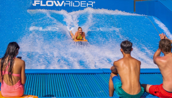 People surfing on the Flowrider at Andamanda Phuket.