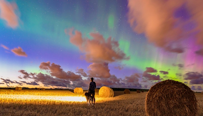 Northern lights illuminating the night sky over a snowy landscape in Norway.
