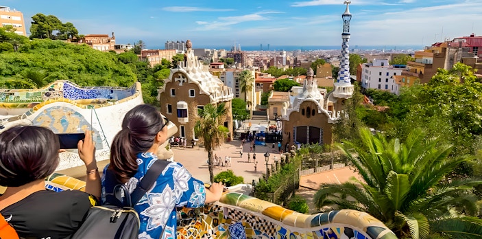 View from Park Güell terrace overlooking Barcelona cityscape.