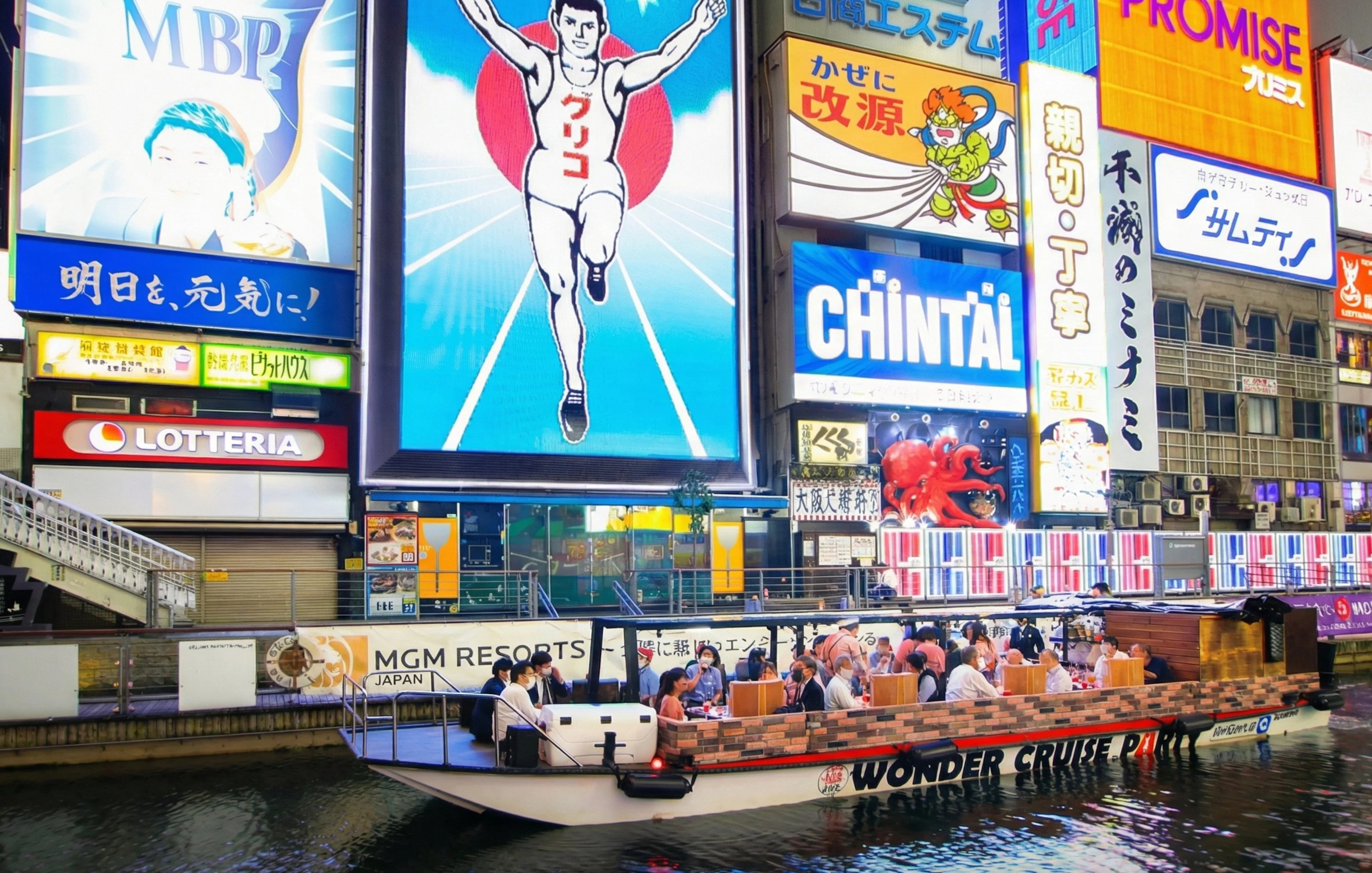 Dotonbori Wonder Cruise passing neon-lit billboards in Osaka at night.