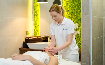 Therapist giving a facial massage at Paskal Thermal Bath, Budapest.