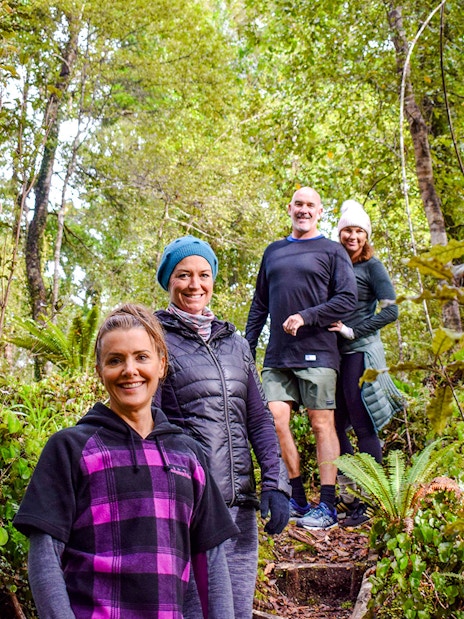 Tourists walking through lush rainforest at Franz Josef.