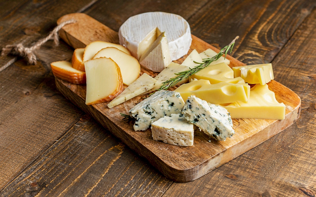 Cheese selection on wooden board at Medieval Dinner Show.
