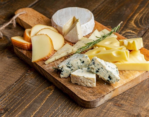 Cheese selection on wooden board at Medieval Dinner Show.