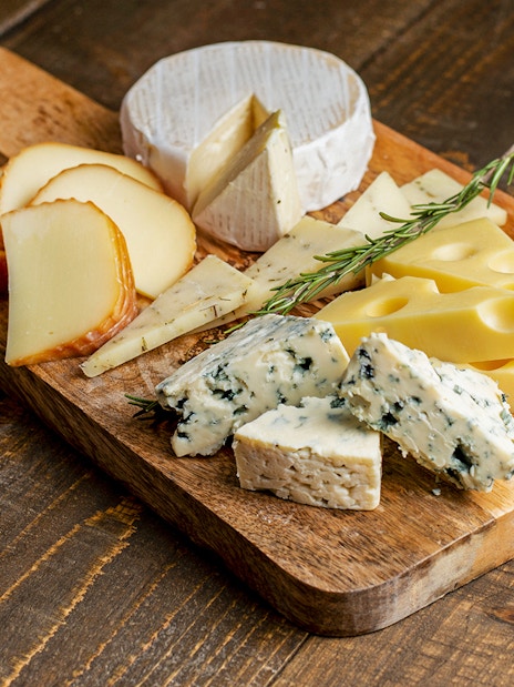 Cheese selection on wooden board at Medieval Dinner Show.
