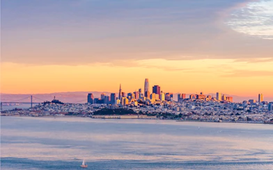 San Francisco skyline with Golden Gate Bridge at sunset.