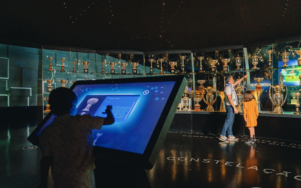 Visitors exploring FC Porto stadium museum trophy display.