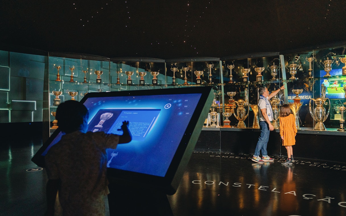 Visitors exploring FC Porto stadium museum trophy display.