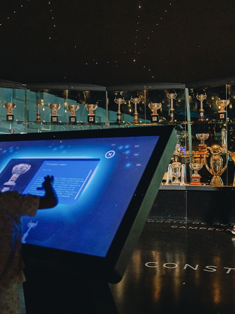 Visitors exploring FC Porto stadium museum trophy display.