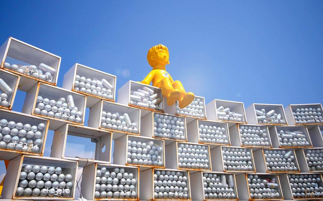 Yellow statue on stacked boxes at Songdo Marine Cable Car, Busan.
