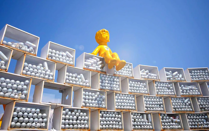 Yellow statue on stacked boxes at Songdo Marine Cable Car, Busan.