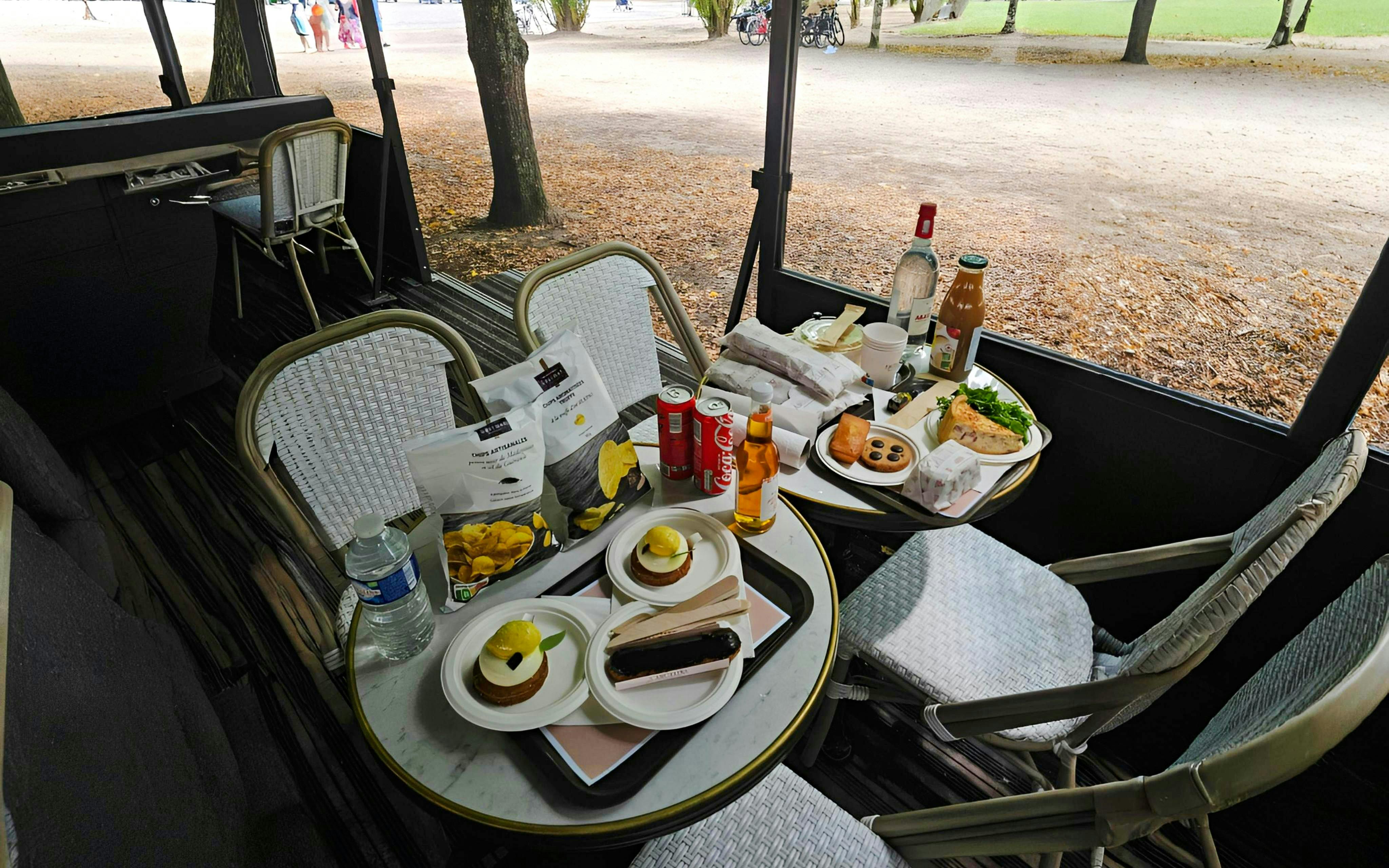 Outdoor picnic setup with snacks and drinks on a table during Versailles Golfcart & Bike Guided Tour.