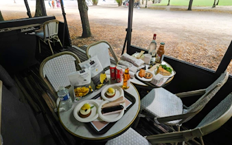 Outdoor picnic setup with snacks and drinks on a table during Versailles Golfcart & Bike Guided Tour.