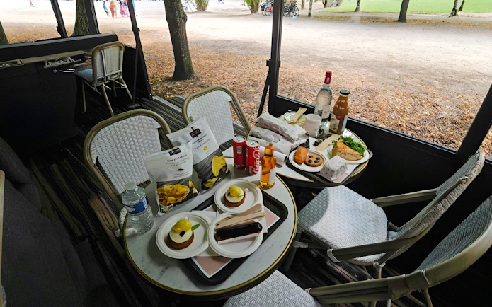 Outdoor picnic setup with snacks and drinks on a table during Versailles Golfcart & Bike Guided Tour.