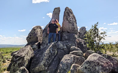 Tourists standing among large rock formations under a clear sky on the Arctic Circle tour.